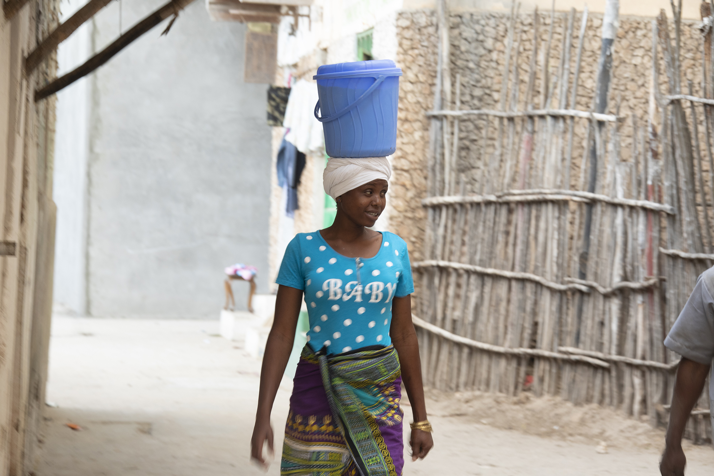 Lamu Woman Walking With Bucket On Head
